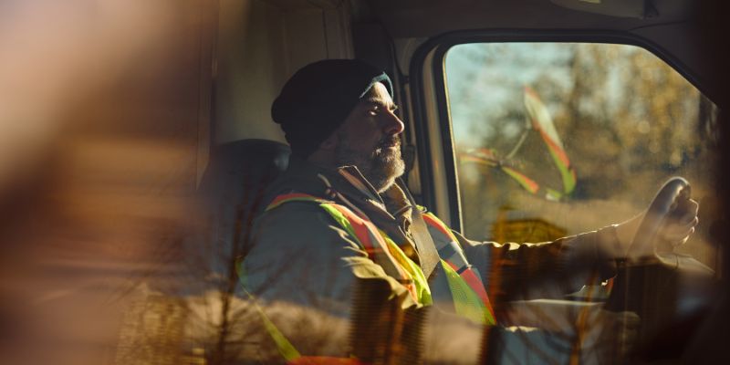 A man delivers cargo, driving a delivery vehicle