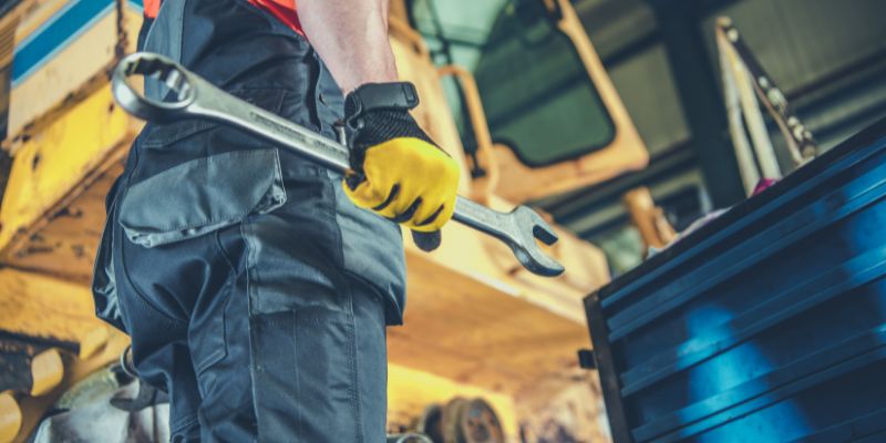 A repairman holds a wrench, ready to replace a liner on a cone crusher