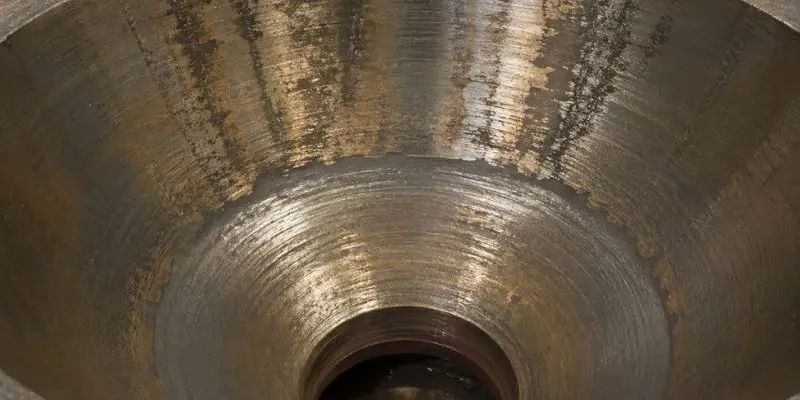 Close-up of cone crusher liners showing wear patterns and surface condition inside the crushing chamber.