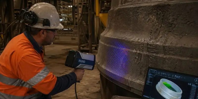 Technician scanning cone crusher mantle and bowl liner with 3D scanner for wear analysis in plant